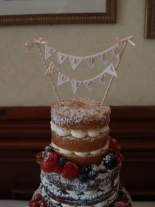 Naked wedding cake with bunting topper